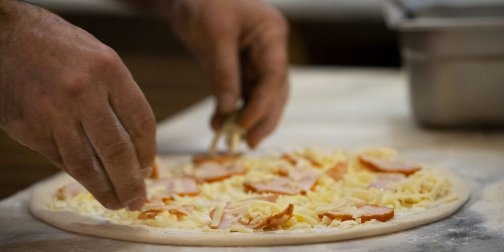 side-view-chef-baking-delicious-pizza